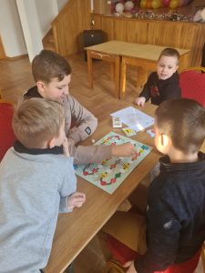 Dzieci przy stoliku grają w gry planszowe