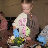 Dzieci wykonują wiosenne kompozycje na warsztatach florystycznych.